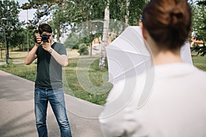 Front view of photographer taking photos behind blurred girl