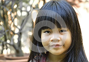 Front view, a portrait of a cute little Asian girl with black hair smiling and looking at a camera. Holiday, happy and healthy