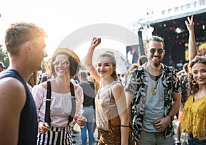 Front view portrait of group of young friends dancing at summer festival.