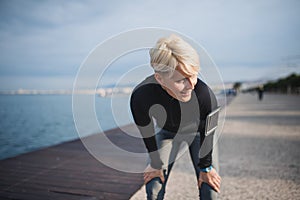 Front view portrait of young sportswoman standing outdoors on beach.