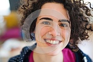 A front view of portrait of young woman indoors, a close-up.