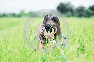 Front view portrait young woman photographer holding camera and