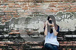 Front view portrait young woman photographer holding camera and