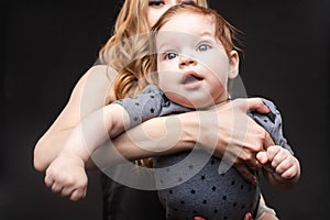 Front view of positive little baby laughing with mother