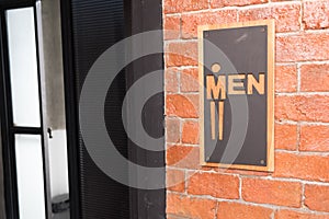 Front view of public restroom or toilet with man signs on brick