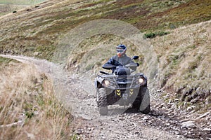 Front view of quad bike zipping along a country road