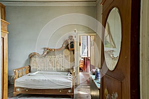 Front view of a room with an antique sofa and an open door to another room