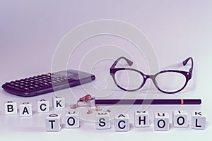 Front view of school supplies with letters spelling the words back to school in girly pink color tones - Concept of student