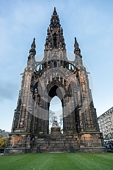 Front view of the Scott Monument in Edinburgh Scotland blue sky and light clouds and fresh clipped green grass at the bottom