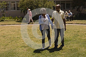 Front view of senior couple holding hands and interacting with each other in garden