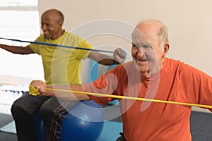 Senior man exercising with resistance band in fitness studio
