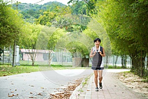 Front view of senior woman jogging through park