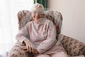 Front view of senior woman looking at camera in home