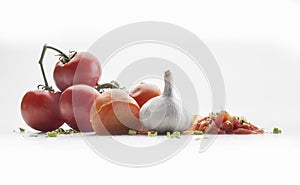 Front view of several tomatoes on a branch, a garlic and chive photo