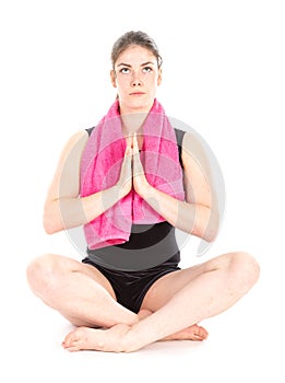 Front view of sitting woman with purple towel, hands together and mediating