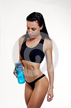 Front view of slim fitness woman drinking water.