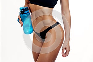 Front view of slim fitness woman drinking water.