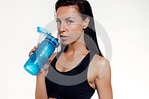 Front view of slim fitness woman drinking water.