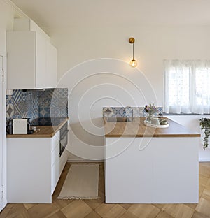 Front view of a small artistic kitchen with a wooden countertop and a small bright window