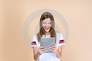 Front view of smiling, adult girl holding tablet in hands