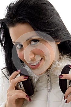 Front view of smiling female holding headphone