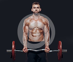 Front view of a strong man bodybuilder exercising with a barbell isolated on black background
