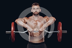 Front view of a strong man bodybuilder lifting a barbell isolated on black background