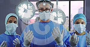 Front view of surgeons gesturing while standing in operating room at hospital