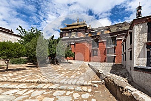 Front view of Tashi Lhunpo Tashilhunpo Monastery  on summer sunny day with blue sky and cloud, Thanka wall in background,