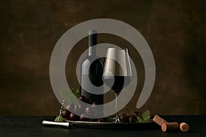 Front view of tasty fruit plate with the wine bottle on dark studio background