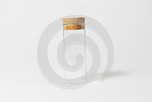 Front view of transparent empty glass jar or test tube bottle with closed brown cork cap lids on white background