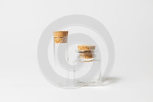 Front view of transparent empty glass jar or test tube bottles with closed brown cork cap lids on white background