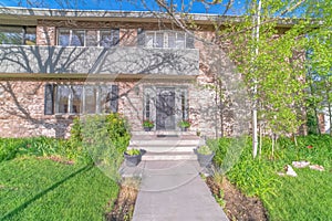 Front view of two storey house on real estate listing with lockbox on door