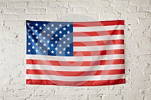 front view of united states of america flag on white brick wall