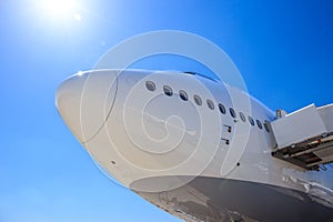 Front view of a white passenger plane waiting on the tarmac of an airport to receive passengers for flight photo