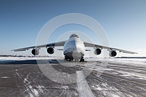 Front view of the white wide body transport cargo airplane at winter airport