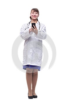Front view of woman doctor looking at her smartphone while smiling