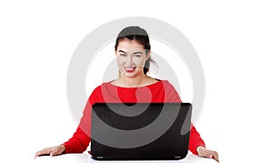 Front view woman sitting at the desk with laptop