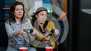Front view of womens playing videogames battle on television using gaming controller