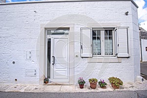 Front view of a wooden white door on white wall