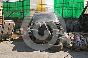 Front view of a wrecked SUV in a parking lot with garbage in the street of Istanbul