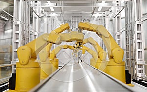 Front view, Yellow robot arms in a production line over a conveyor belt in a modern factory