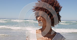 Front view of young African american woman walking on beach in the sunshine 4k