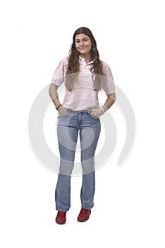 front view of a young girl standing with hands on pockets on white