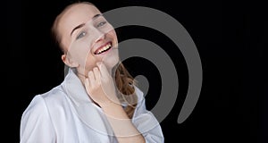 Front view of a young intellectual doctor on a black background with text space. A candid doctor`s smile