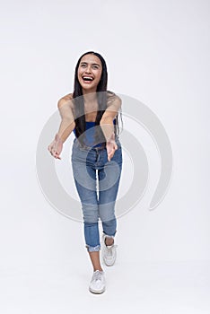 Front view of a young southeast asian woman tries to catch something falling. Reaching out with her arms. Full body photo isolated