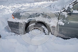 The front wheel of the car is stuck in a snowdrift. Snow drift