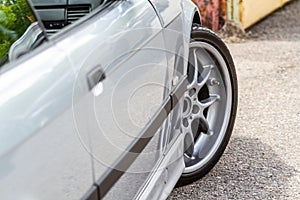 Front wheel and door of a gray car. Rear view of the car. Horizontal orientation. High quality photo