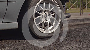 Front wheel drive drag racing car is burning tire at start line