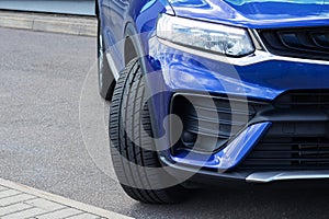 The front wheel and headlight of the car